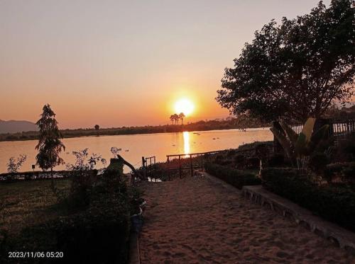 a sunset over a body of water with the sun setting at Mwanati Executive Lodge in Liwonde