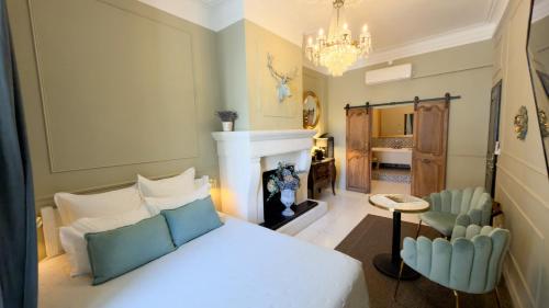 a bedroom with a bed and a fireplace and a chandelier at Le 215 Gambetta boutique hôtel en Provence in Cavaillon