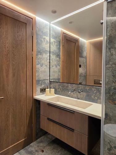 a bathroom with a sink and a mirror at Central Apartament in Telšiai