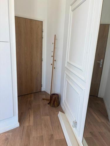 an empty room with a door and a wooden floor at Mendess suites in Palaiseau