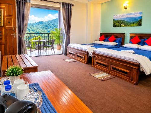 a bedroom with two beds and a balcony at Kithaya Ella in Ella