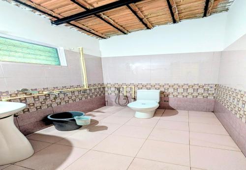 a bathroom with a toilet and a sink at The Lantana Resorts in Madikeri