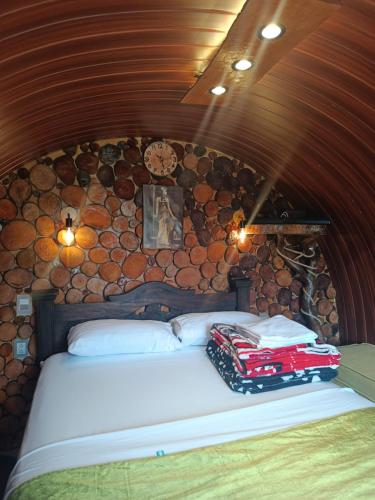 a bed in a room with a wall of logs at Paraíso del Chicamocha in Aratoca