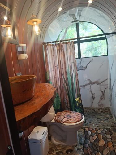 a bathroom with a toilet and a sink and a window at Paraíso del Chicamocha in Aratoca