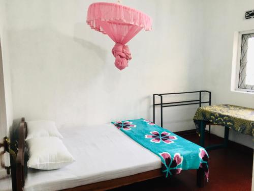 a bedroom with a bed with a pink umbrella at Sansa HomeStay in Bandarawela