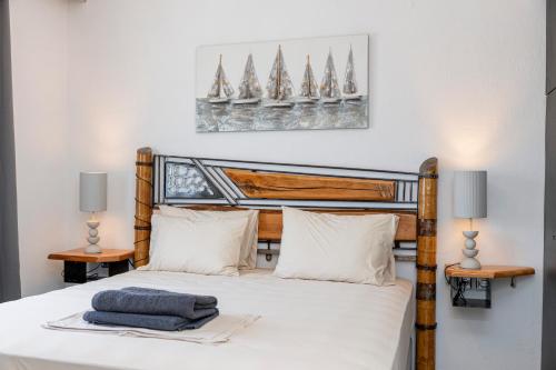 a bedroom with a bed with white sheets and two lamps at Vila Petro in Evkarpía
