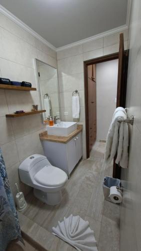 a bathroom with a white toilet and a sink at SEMEREL APARTMENT in Palm-Eagle Beach