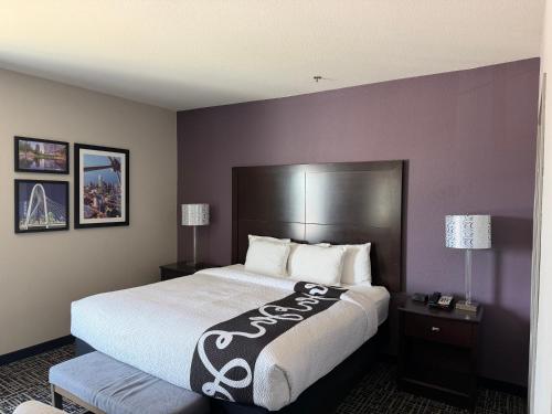 a hotel room with a large bed and two lamps at La Quinta by Wyndham DFW Airport West - Euless in Euless