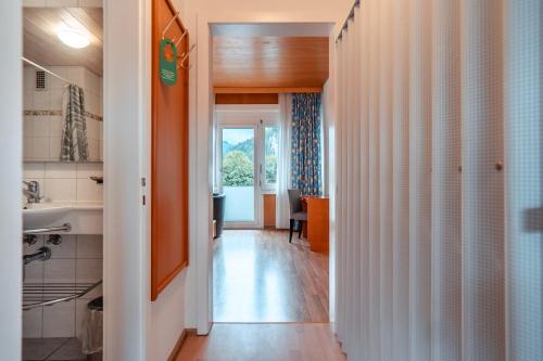 a hallway leading to a kitchen with a sink at Parkhotel Bellevue Budget in Lenk