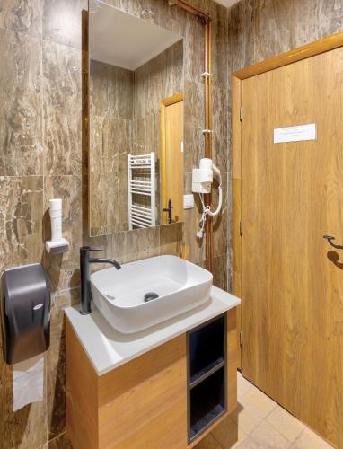 a bathroom with a sink and a mirror at Hotel SINAN HAN in Mostar