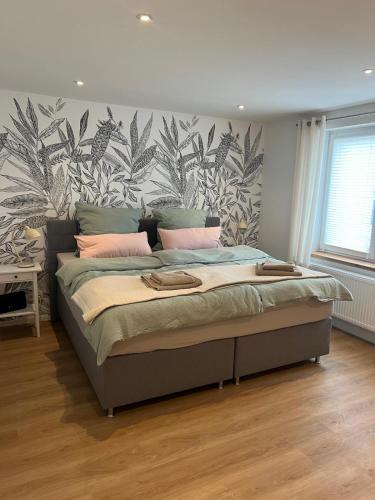 a bedroom with a bed with a tropical wallpaper at Landliebe Wemb in Weeze