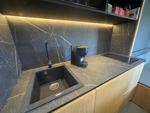 a kitchen counter with a sink and a coffee maker at Fra Rooms in Taormina