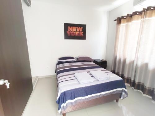 a bedroom with a bed with a new work sign on the wall at Casa Barcelona in Santa Cruz de la Sierra