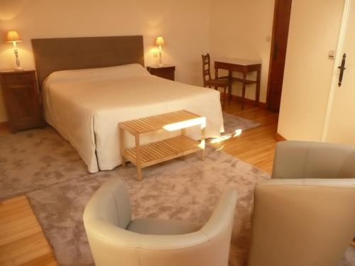 1 dormitorio con 1 cama, mesa y sillas en Galot La Chapelle en Gardegan-et-Tourtirac
