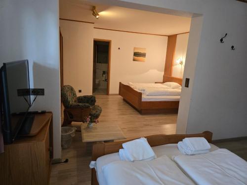 a hotel room with two beds and a television at Hotel Zur Buche 24h Check-in, Free in Bockhorn