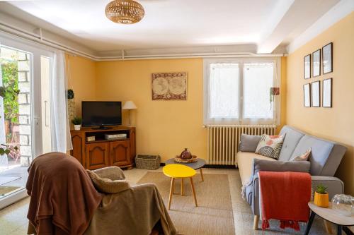 a living room with a couch and a tv at La Soleillade in Manosque