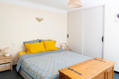 a bedroom with a bed with yellow pillows at La Soleillade in Manosque