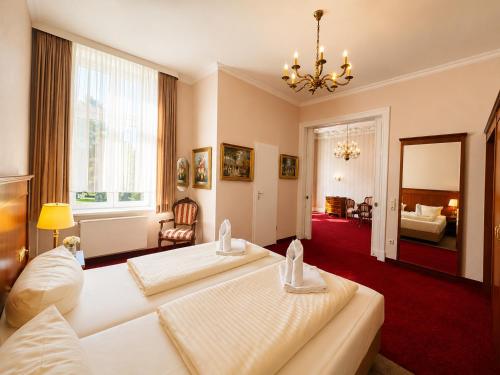 a bedroom with two beds and a living room at Hotel Kaiserhof in Lübeck