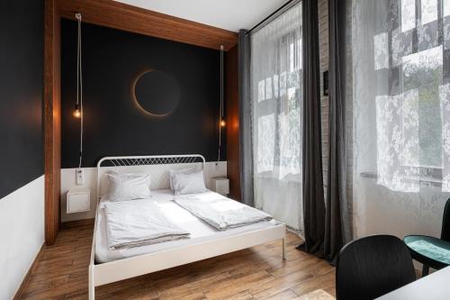 a bedroom with a white bed and a black wall at Bohem Prague Hotel in Prague