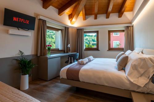 a bedroom with a large bed and windows at Casa Sgubin in Cormòns