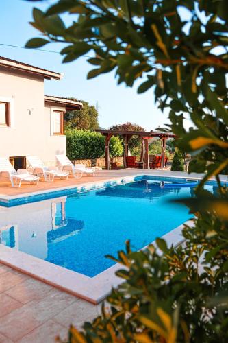 a swimming pool with chairs and a house at Holiday Home Senko in Blagaj