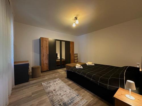 a bedroom with a bed with a black comforter at Dielli's house in Gnjilane