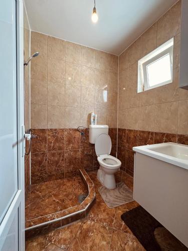 a bathroom with a toilet and a tub and a sink at Dielli's house in Gnjilane