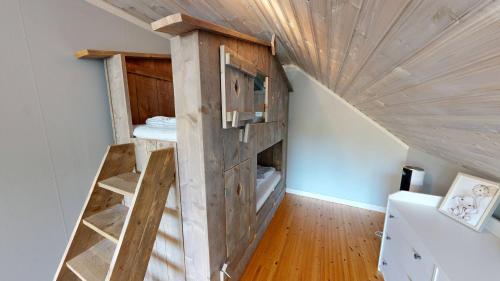 a loft bed in a room with a wooden ceiling at Villa Seeblick in Vissefjärda