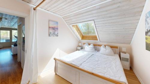 a white bedroom with a bed in a room at Villa Seeblick in Vissefjärda