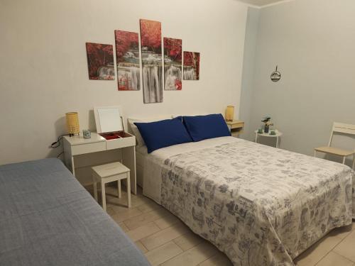 a bedroom with a bed with blue pillows and a desk at Il sentiero delle fate in Caserta