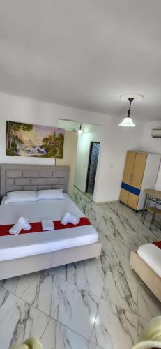 a bedroom with a bed and a marble floor at Koci Apartments in Sarandë