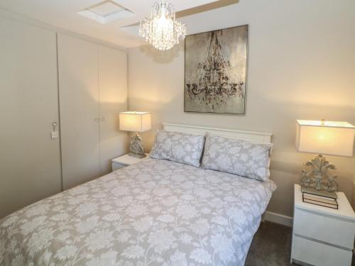 a bedroom with a bed with two night stands and a chandelier at Lake Side Cottage in Wakefield