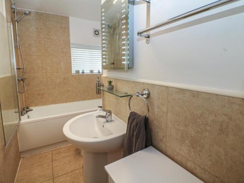 a bathroom with a sink and a toilet and a tub at Lake Side Cottage in Wakefield