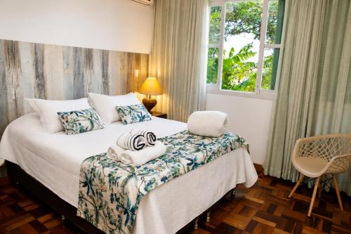 a bedroom with a bed with towels on it at Bem-estar e boa localização (Apto Paraíso) in Maringá