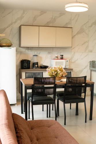a kitchen with a table and chairs and a kitchen with a refrigerator at Ypê Flats e Containers in Bonito
