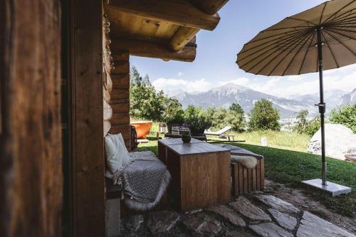 a patio with a table and an umbrella at Maiensäss, Berghütte Chlara - autark, voll ausgestattet, Ressourcen begrenzt in Untervaz