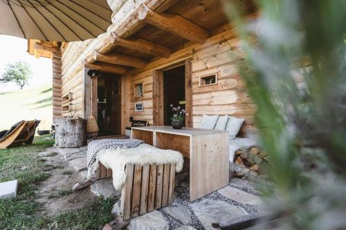 a wooden cabin with a table and a bench at Maiensäss, Berghütte Chlara - autark, voll ausgestattet, Ressourcen begrenzt in Untervaz