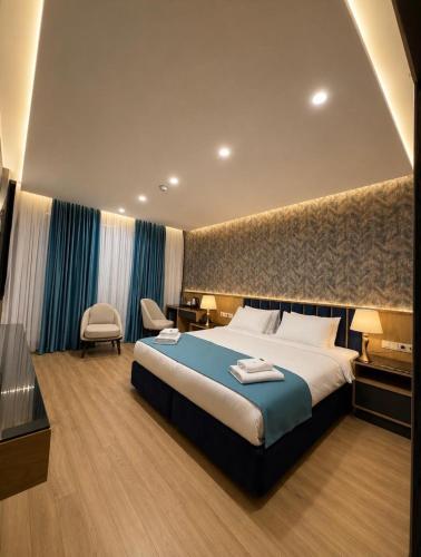 a hotel room with a large bed and a chair at The New Jai Son in Kobuleti