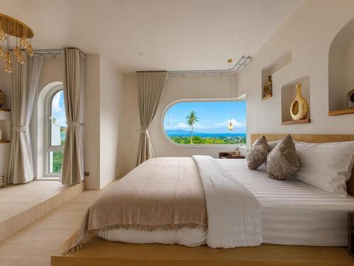 a bedroom with a large bed with a large window at CASA MARINe in Bophut