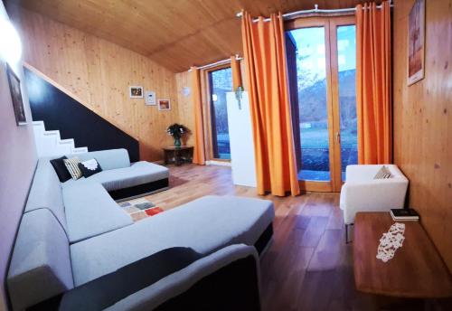 a living room with white furniture and a staircase at Centrul 3H in Sub Piatra