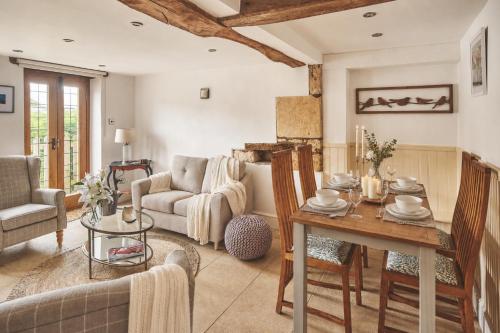 a living room with a table and a couch at Squirrel Barn in Moreton in Marsh