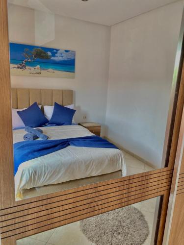 a bedroom with a bed with blue pillows at Agadir City Appartement in Agadir