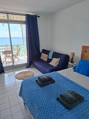 a bedroom with a bed and a couch with a balcony at GAP in Le Diamant