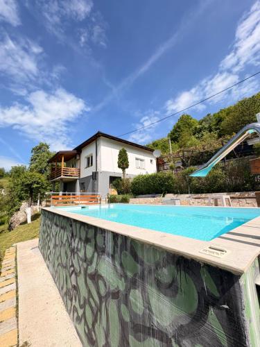 a swimming pool in front of a house at Vikendica Brda in Banja Luka