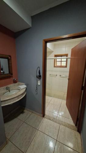 a bathroom with a shower and a sink at Pousada Beco da Lua in Olímpia