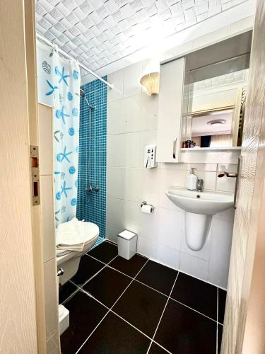 a bathroom with a sink and a toilet at Deniz Kenarı Beach & Garden in Ayvacık
