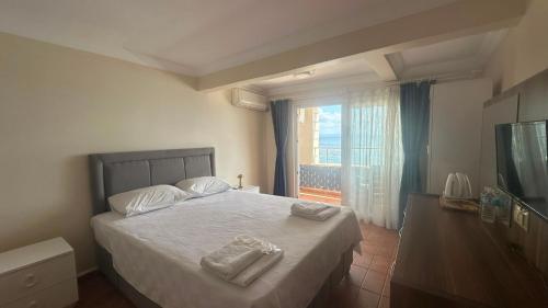 a bedroom with a bed with two towels on it at Deniz Kenarı Beach & Garden in Ayvacık