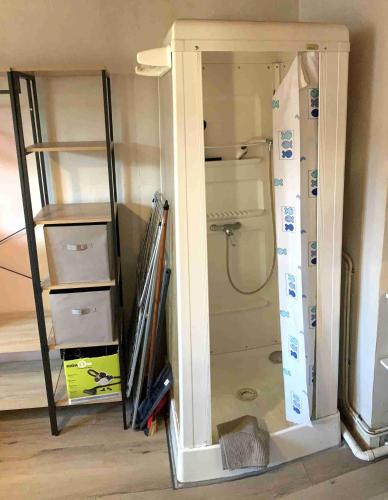 a kitchen with a refrigerator and some shelves at Weaky what you want in Ugine
