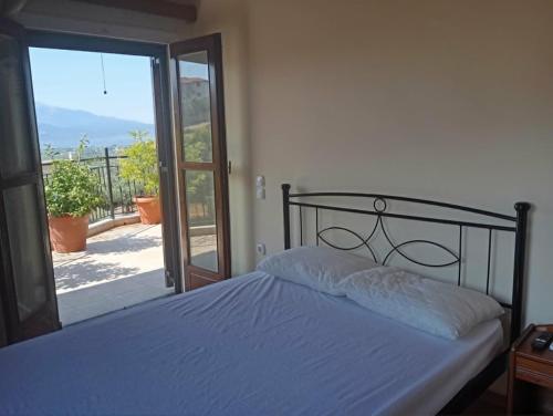a bedroom with a bed and a door to a balcony at villa vitta - bellissimo villagio in Kastrákion