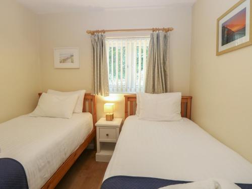 two beds in a small room with a window at 15 The Dell in Norwich